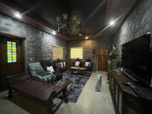 a living room with a couch and a tv at CASA HERNANDO Private Resort in Apalit