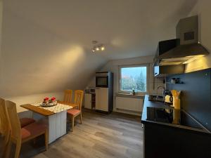 a kitchen with a table and a small kitchen with a window at Ferienwohnung in Buttenheim bei Bamberg in Buttenheim