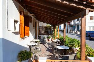 a patio with tables and chairs on a building at Lefteris Rooms in Kokkari