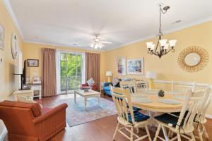 a dining room and living room with a table and chairs at Havens on the Nine condo in North Myrtle Beach