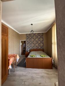 a bedroom with a bed and a table in it at Magdan house in Tsqaltubo
