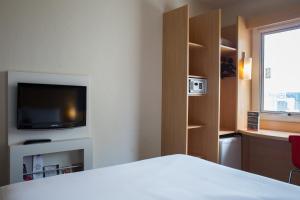 a hotel room with a bed and a flat screen tv at ibis Rio de Janeiro Centro in Rio de Janeiro