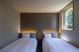 Voodi või voodid majutusasutuse Kiryu Grand Hotel toas