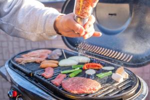 a person is cooking meat and vegetables on a grill at Third Place Nagano in Matsumoto
