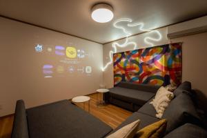 a living room with a couch and a painting on the wall at Third Place Nagano in Matsumoto