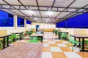 a cafeteria with tables and chairs and blue walls at Townhouse Oak White town Rock Beach in Puducherry