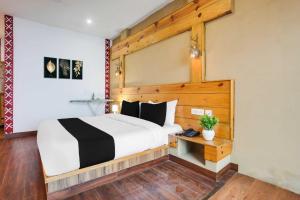 ムスーリーにあるTownhouse Oak Mussoorie Lakeの木製のヘッドボードが付いた大きなベッドのある寝室 +27枚の写真