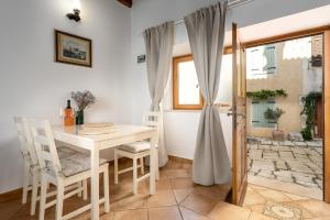 a dining room with a white table and chairs at Studio Apartment Ana in Vrsar