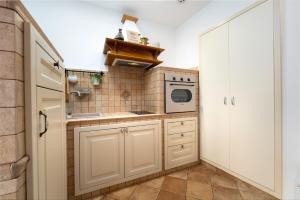 a small kitchen with white cabinets and a microwave at Studio Apartment Ana in Vrsar