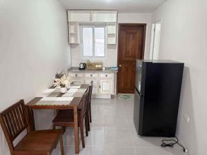 a kitchen with a table and a black refrigerator at JV tRansient 24 in Ormoc +4 photos