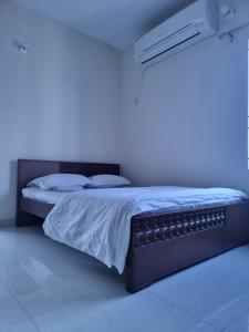 ダッカにあるEcon Stay in New Apartment, Jigatola, Dhanmondi, Dhaka, Bangladeshの青いライトが備わるドミトリールームのベッド1台分です。