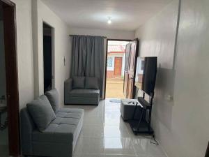 a living room with a couch and a tv at JV tRansient 24 in Ormoc