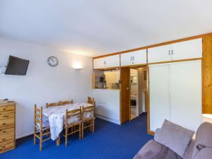 a room with a table and a couch and a kitchen at Studio cabine au centre avec accès direct aux pistes - FR-1-400-101 in Eaux-Bonnes