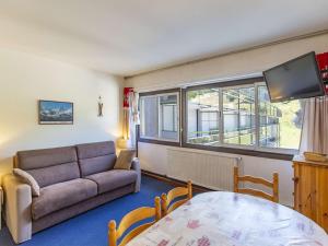 a living room with a couch and a table at Studio cabine au centre avec accès direct aux pistes - FR-1-400-101 in Eaux-Bonnes