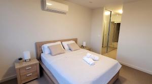 a bedroom with a bed with two towels on it at Lakeside Retreat in Caroline Springs