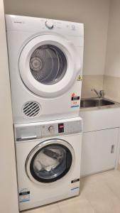 a washer and dryer in a kitchen with a sink at Lakeside Retreat in Caroline Springs