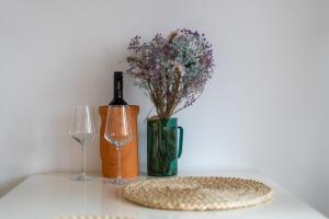 a table with a bottle of wine and a vase of flowers at Studio Apartment Ana in Vrsar