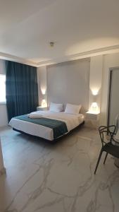 安曼Antonio Hotel Amman的一间卧室,有一张大床,配有两盏灯