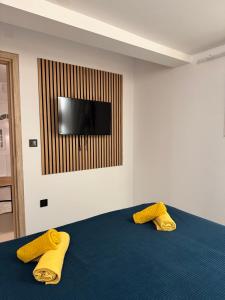 a bedroom with two yellow pillows on a blue bed at Apartman Family Aleksandrov in Néa Meságkala