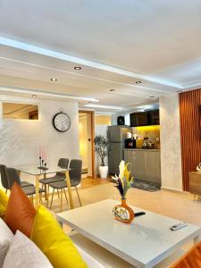 ein Wohnzimmer und eine Küche mit einer Uhr an der Wand in der Unterkunft C1, Chic Seaside Stay at Carrousel Mall, Walk Everywhere in Rabat