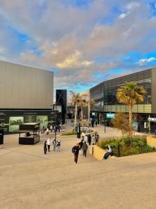eine Gruppe von Menschen, die vor einem Gebäude spazieren gehen in der Unterkunft C1, Chic Seaside Stay at Carrousel Mall, Walk Everywhere in Rabat