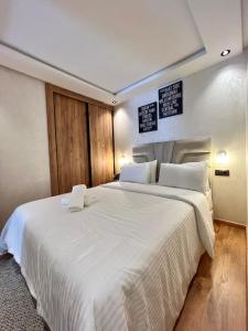 ein Schlafzimmer mit einem großen weißen Bett mit zwei Kissen in der Unterkunft C1, Chic Seaside Stay at Carrousel Mall, Walk Everywhere in Rabat