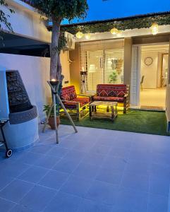 eine Terrasse mit Sofas, einem Tisch und einem Baum in der Unterkunft C1, Chic Seaside Stay at Carrousel Mall, Walk Everywhere in Rabat