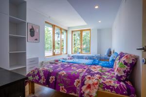 a bedroom with a bed with a purple comforter at Capital Stay in Sarajevo