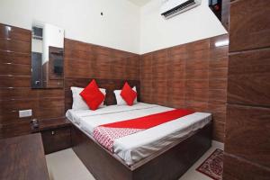 Un dormitorio con una cama con almohadas rojas. en Rainbow Inn, en Nueva Delhi