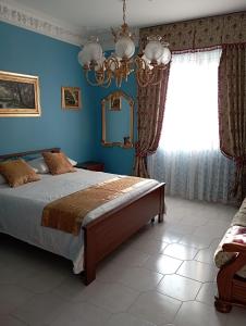 a bedroom with a bed with blue walls and a window at Antica Montesicco, casa vacanze in campagna in Mirabella Eclano
