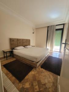 a bedroom with a large bed and a window at Résidence El atlas in Marrakech