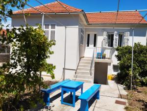 a blue table and benches in front of a house at Sobe Tramontana in Murter +28 photos