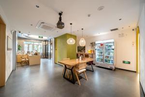 a kitchen and dining room with a table and chairs at Dengba Inn - Shanghai Stadium Tianyaoqiao Road Branch in Shanghai
