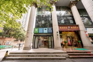 a building with columns and stairs in front of it at Dengba Inn - Shanghai Stadium Tianyaoqiao Road Branch in Shanghai
