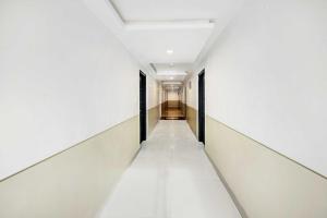an empty corridor in a building with white walls and ceilings at Townhouse Oak City Center Mysore Palace in Mysore