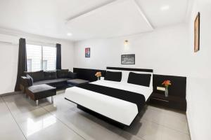 a bedroom with a black and white bed and a couch at Townhouse Oak City Center Mysore Palace in Mysore