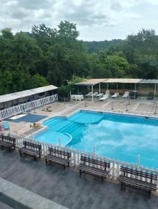 una gran piscina azul con bancos y sillas en A casa di Carolina, en Monti di Licciana Nardi