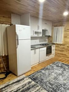 Una cocina con gabinetes blancos y un refrigerador. en Karatay Villas, en Demre