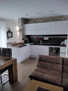 a kitchen with white cabinets and a couch and a table at CroStar in Pješčana Uvala  +38 photos