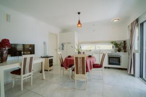 uma cozinha com mesa e cadeiras e uma cozinha com electrodomésticos brancos em Mahakala Center em Petrovac na Moru