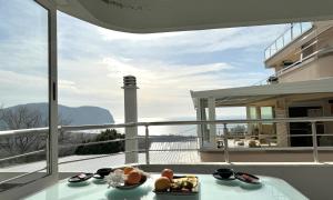 een balkon met een tafel en uitzicht op een vuurtoren bij Mahakala Center in Petrovac na Moru