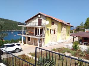a house with a car parked in front of it at Apartment Bigovo in Tivat