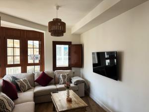 a living room with a couch and a tv at Las Cuatro Calles in Ribadeo