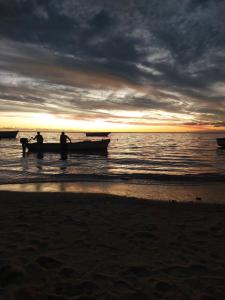 2 persone in barca sulla spiaggia al tramonto di Studio de la plage d'Albion a Mauritius Altre 6 foto