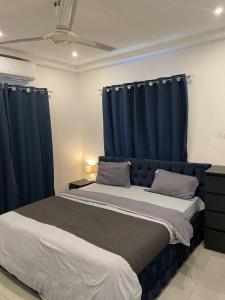 a bedroom with two beds with blue curtains at Premium Apartments in Santeo