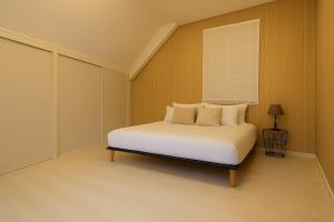 a bedroom with a white bed and a window at Nid douillet proche Mer in Saint-Valéry-en-Caux