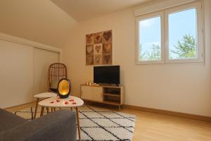 a living room with a couch and a tv at Nid douillet proche Mer in Saint-Valéry-en-Caux