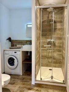 a bathroom with a shower and a washing machine at Séjour de charme au marais bleu in Amboise