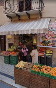 two people standing in front of a fruit market at Vecchia Sicilia in Gela