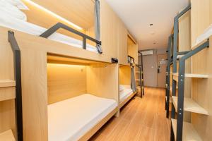 a dorm room with bunk beds and wooden floors at Dengba Inn - Shanghai Stadium Tianyaoqiao Road Branch in Shanghai +73 photos